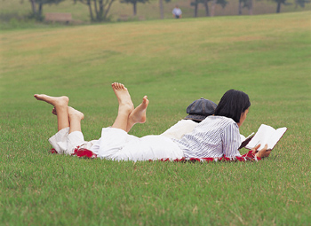 Bild på läsande ungdomar på en gräsmatta.