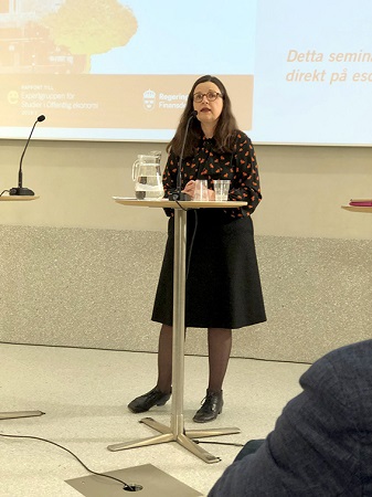 Bild på Anna Ekström, mörkhårig kvinna som framför en presentation.