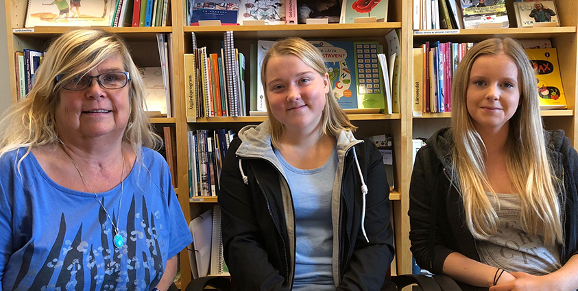 Bild på Inger Rålenius,Fredrika Rosenquist och Celine Medina, de tre sitter bredvid varandra inne på ett bibliotek.