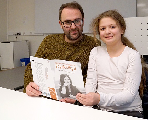 Bild på far och dotter som sitter och läser en broschyr