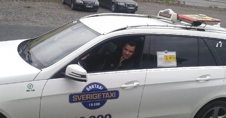 Taxiförare i  taxi med texten Örn-taxi på sidan