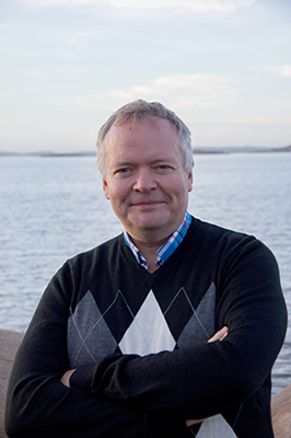 Bild på Stefan Johansson, man iklädd svart tröja som står framför vattnet.