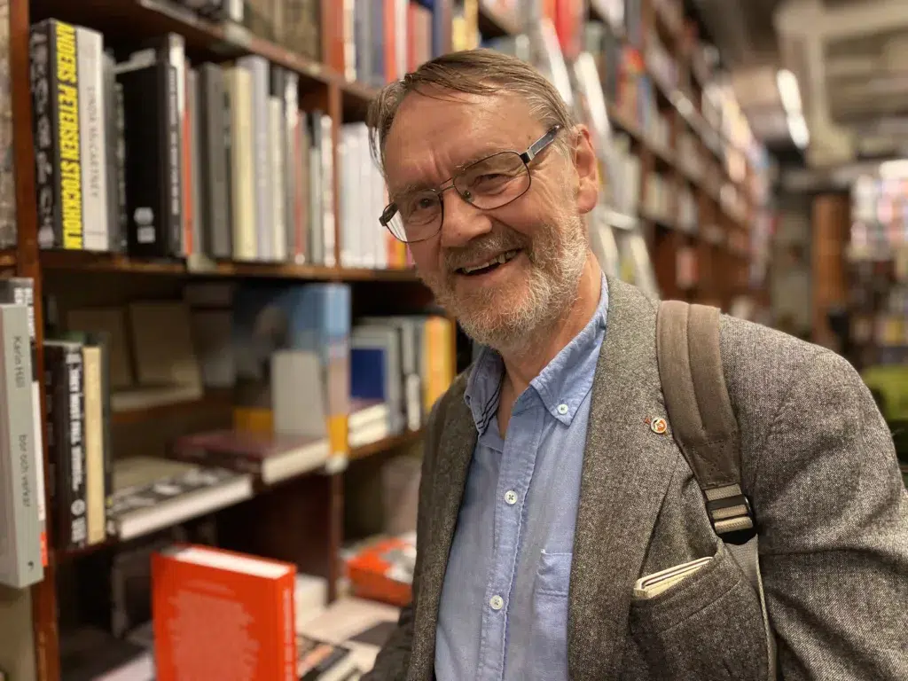 Torbjörn Lundgren framför en bokhylla.