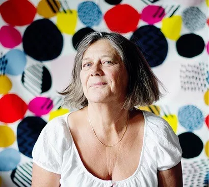 Helene Lumholdt framför vägg med färgglada prickar.