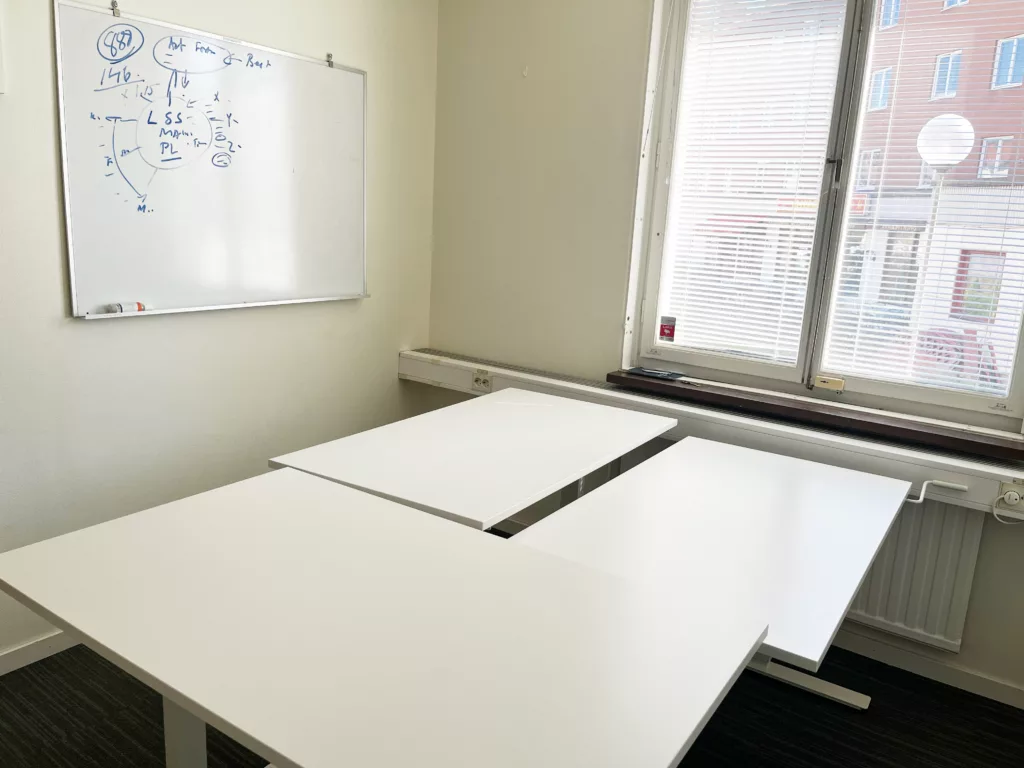 Kontor med bord och whiteboardtavla.