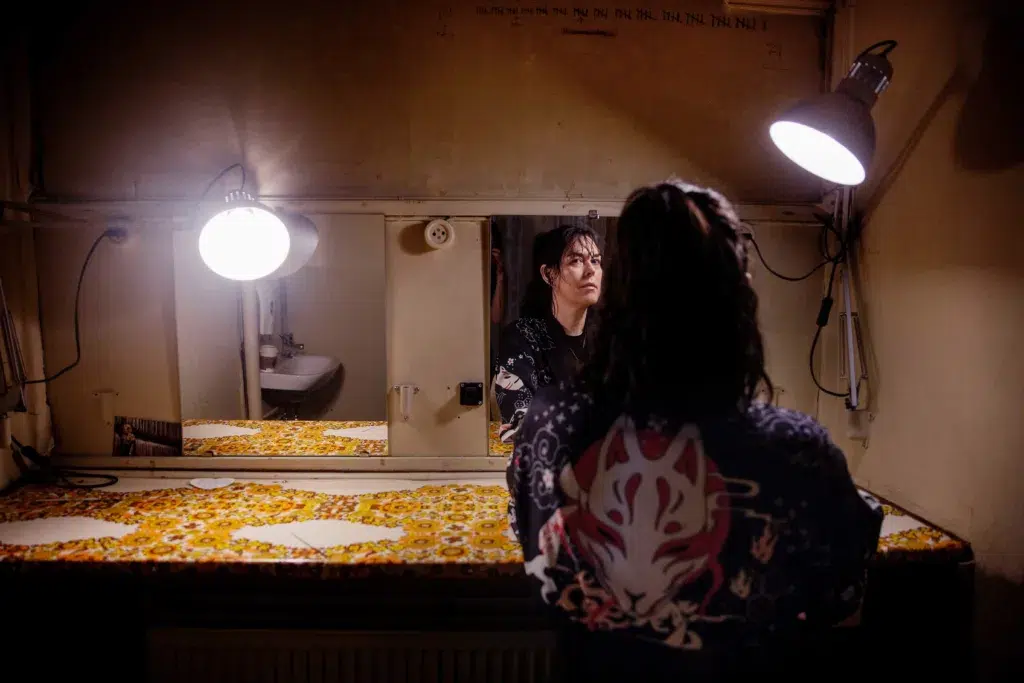 Adrian i en loge ser sig i spegeln