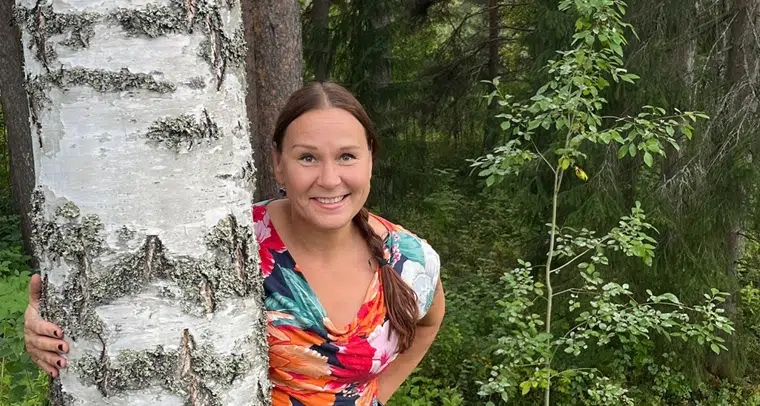 Kvinna med långt brunt hår utomhus.