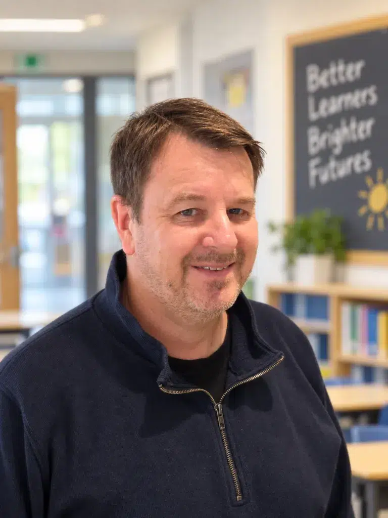 Man (Patrik Åhman) i skolmiljö. Brunt hår, svart tröja.