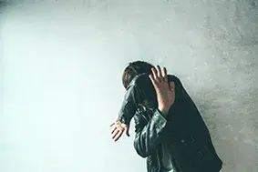 Man som skyddar sitt ansikte från våldsam attack.